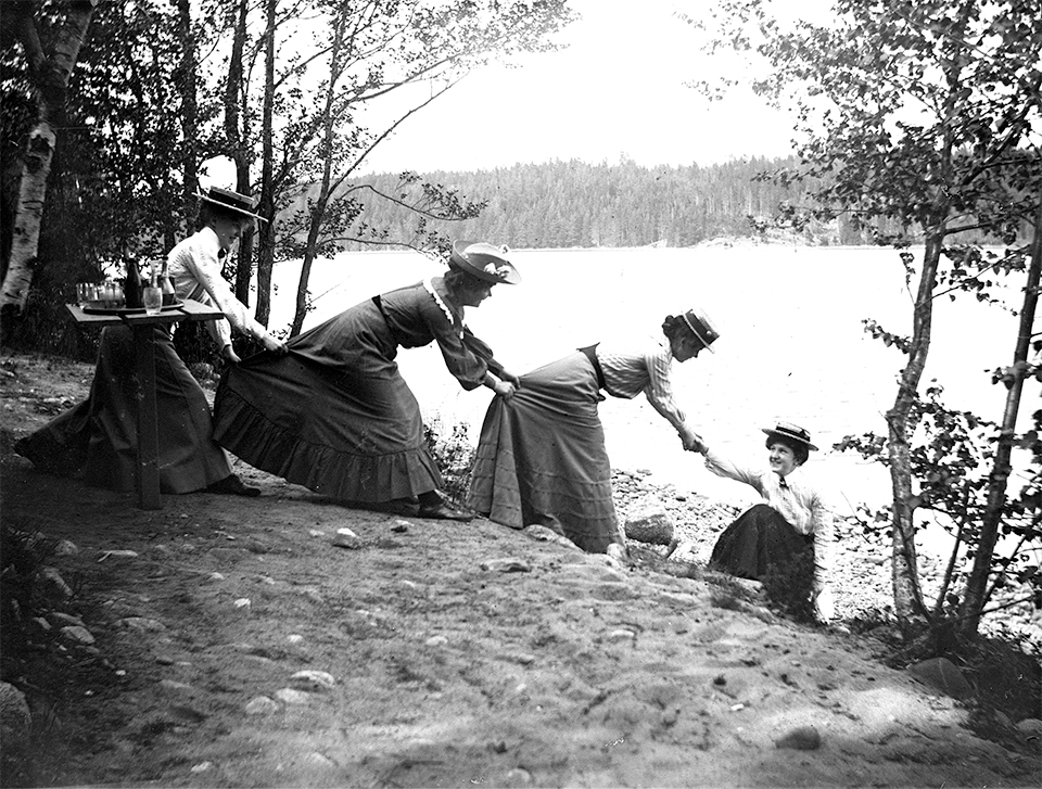 Tre kvinnor i rad som drar upp en kvinna ur sjön