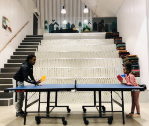 Två barn som spelar pingis vid ett pingisbord