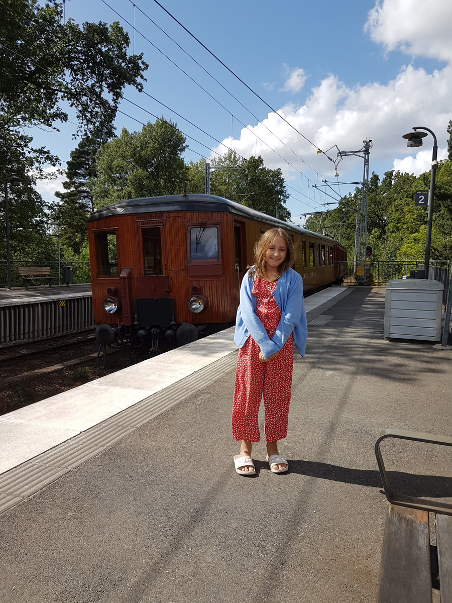 Laura med gamla tåget vid Storängens station.​  Av en slump fick vi åka med det gamla tåget. Kul, tyckte Laura och Mamma.