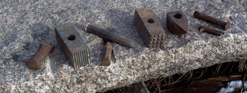 Delar av verktyg som ligger på en sten.