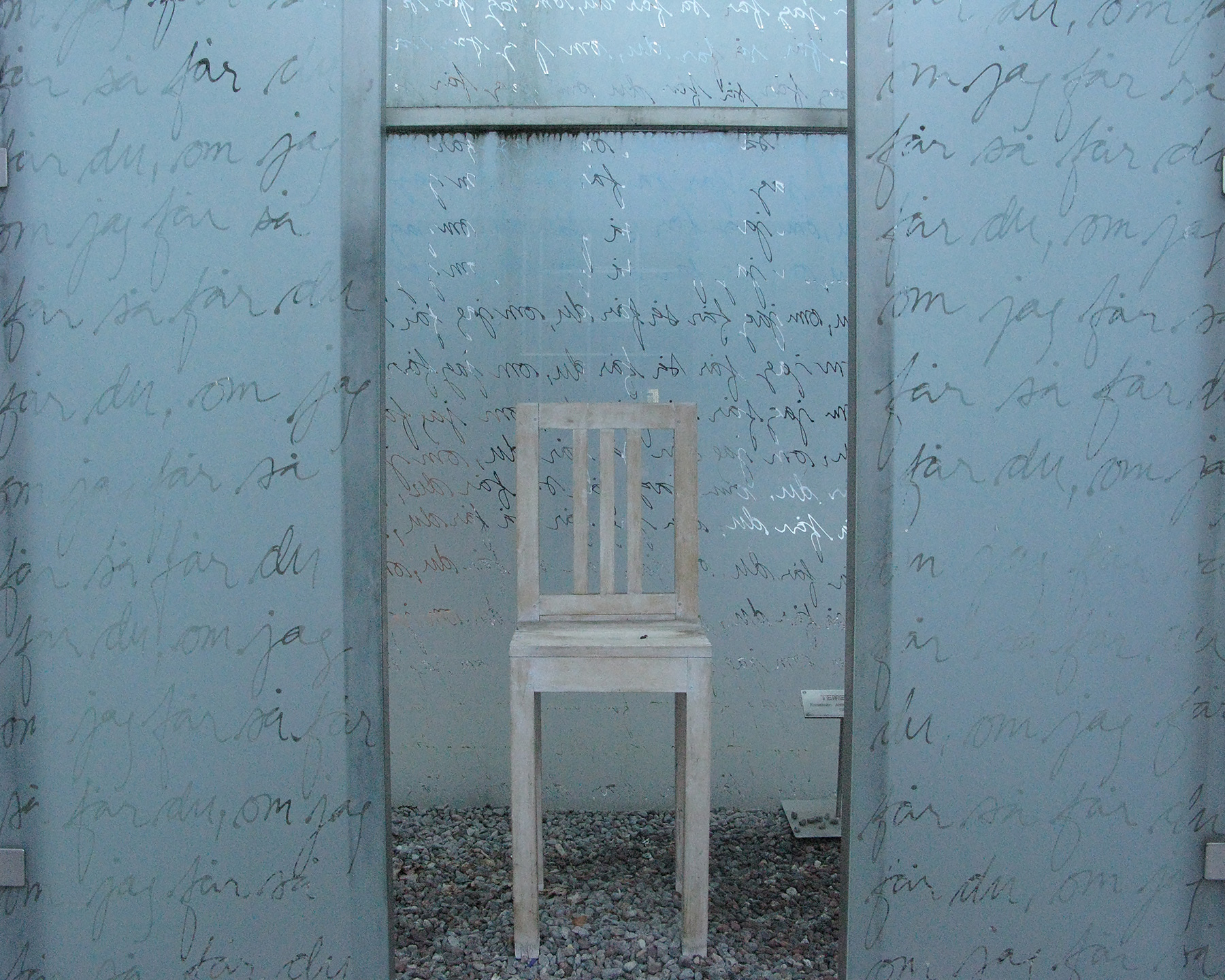 En stol som är avskärmad med väggar av blästrat glas.