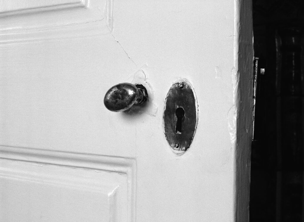 Närbild på ett dörrvred och ett nyckelhål.