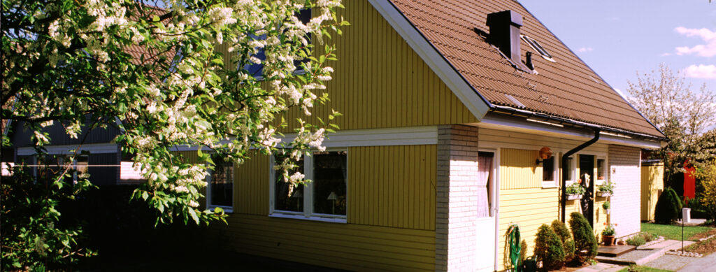 Ett hus av trä, hörnen på huset har tegel.