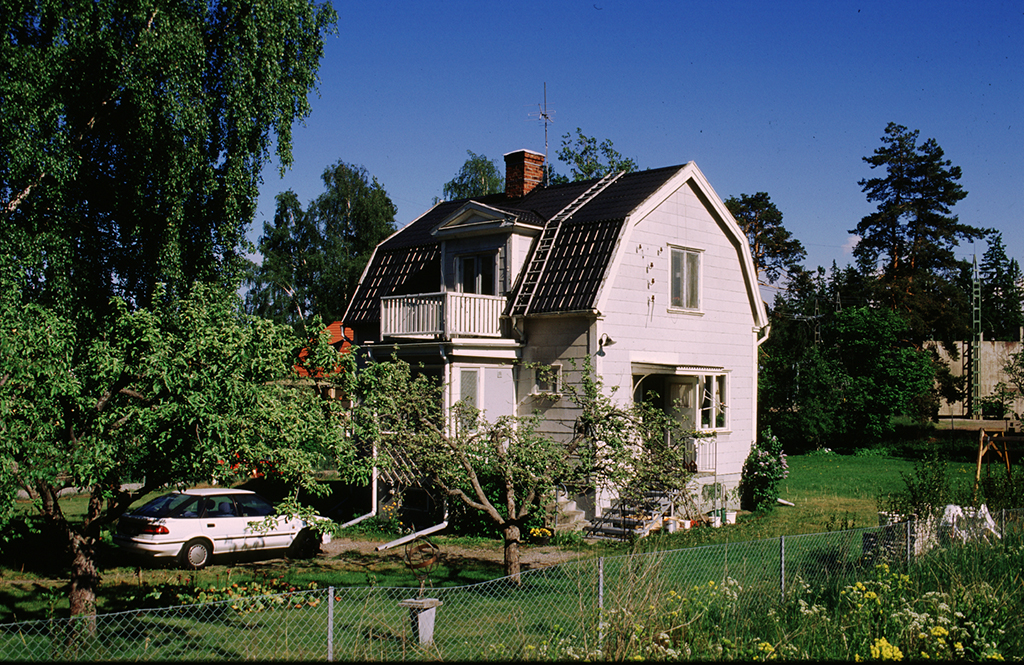 Ett hus som står i en grönskande trädgård.