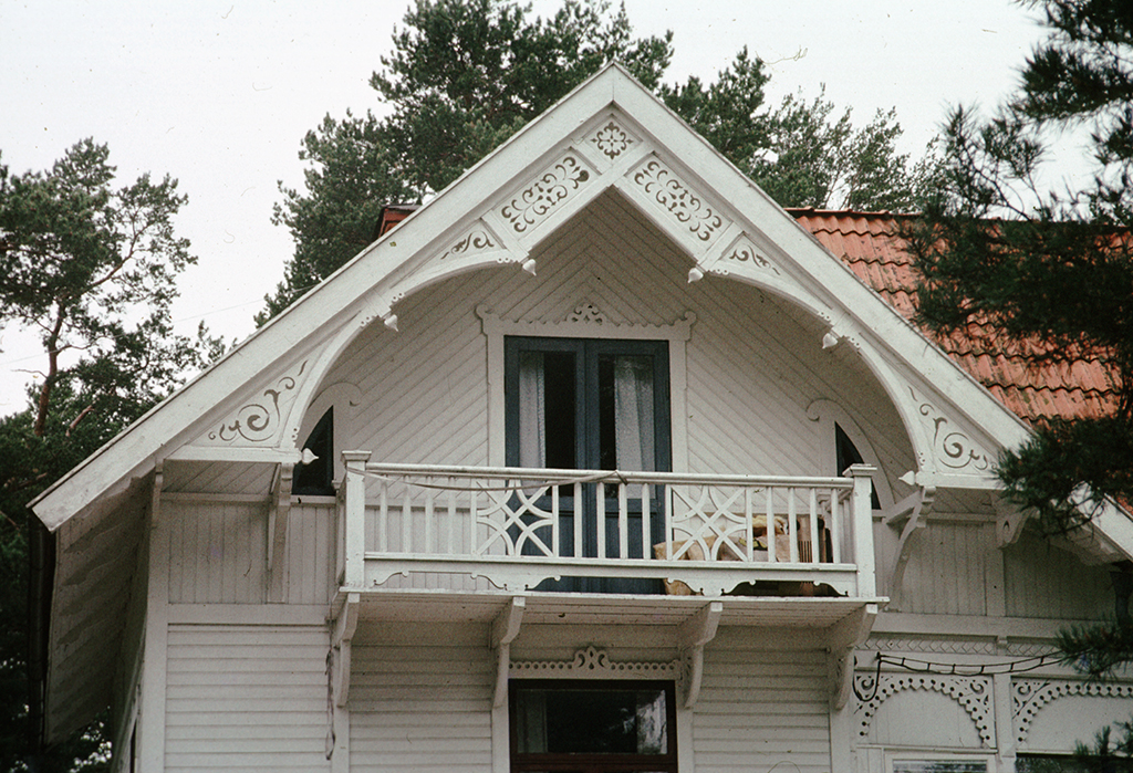 Ett hus med balkong och mönstrade plankor.