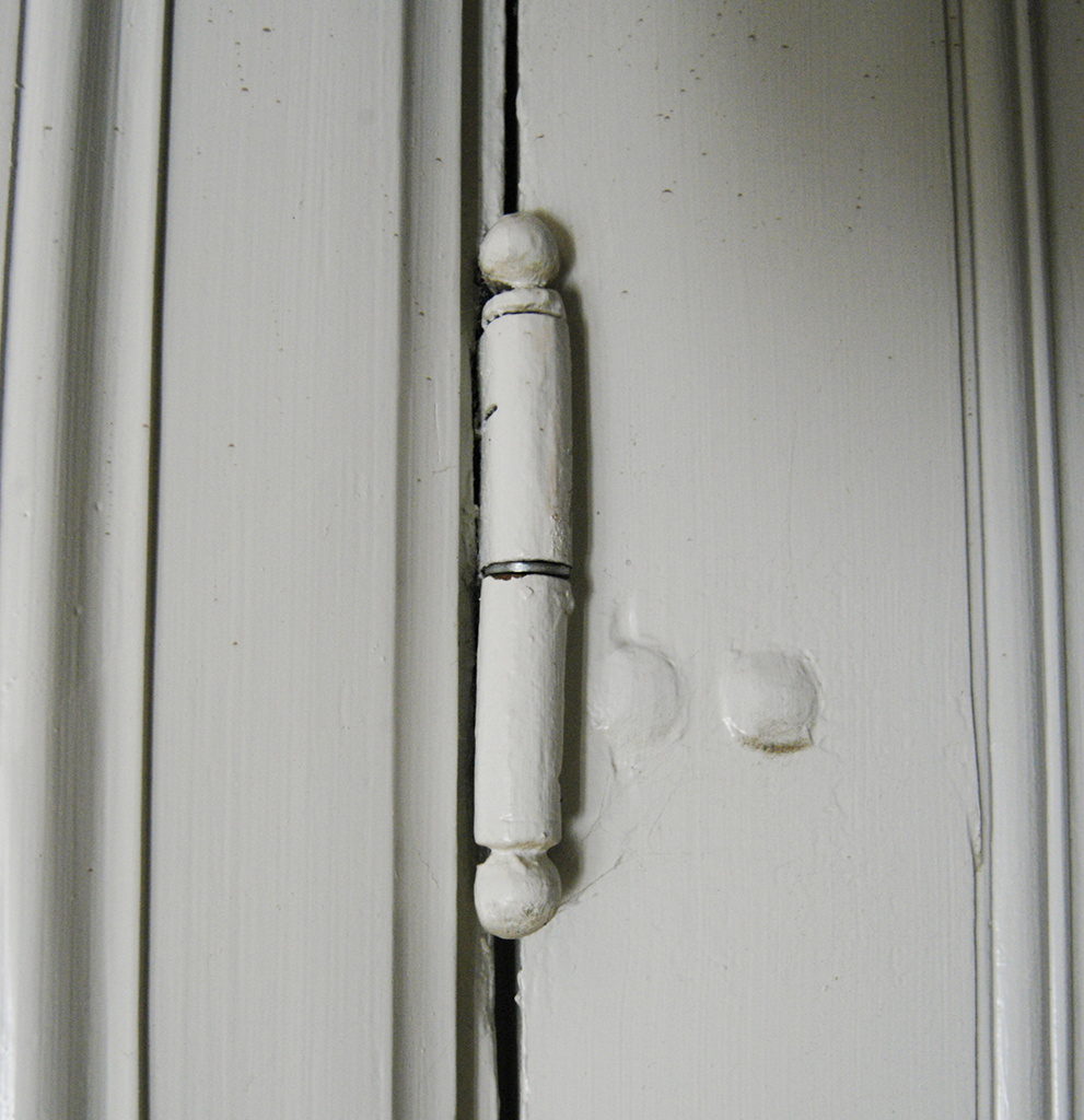 Närbild på ett gångjärn som sitter på en dörr.