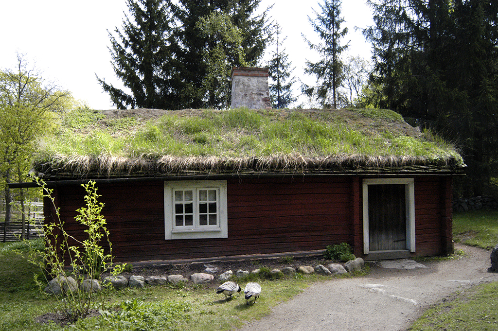 Ett litet hus med gräs på taket.