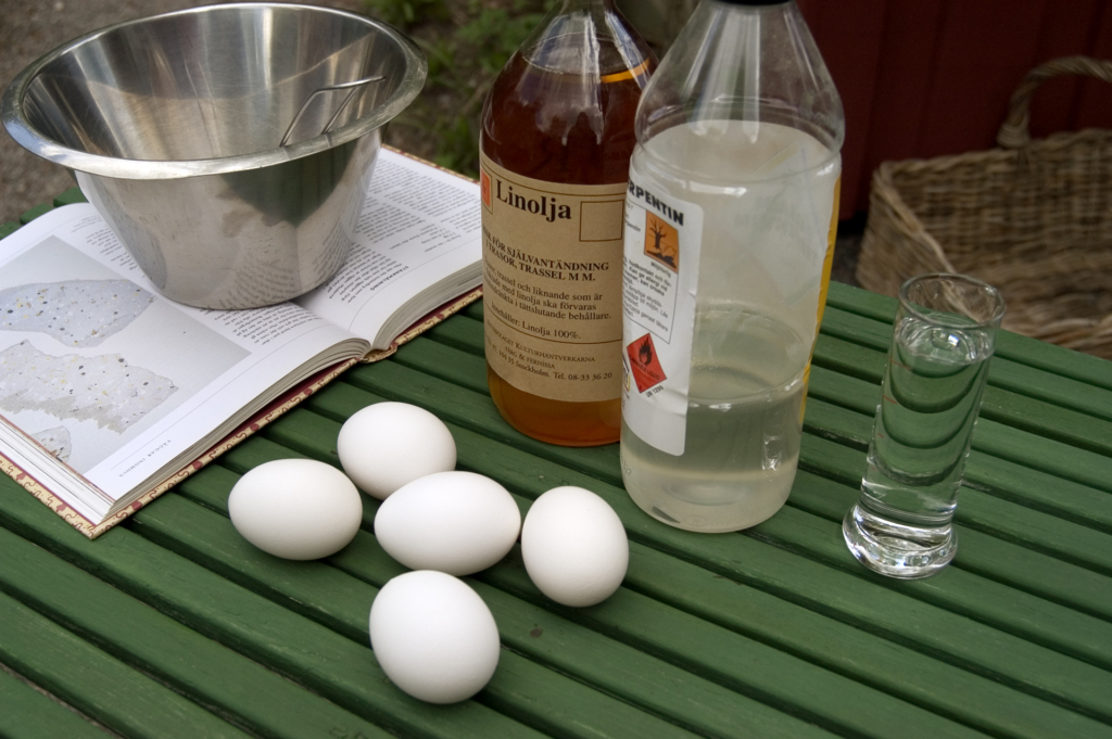 Fem ägg ligger på ett bord, bredvid står flaskor med innehåll.