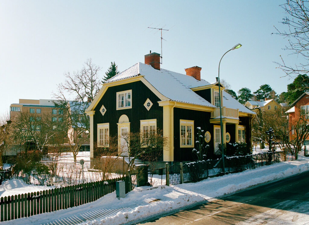 Ett hus står på en gata i ett bostadsområde. Det är vinter.