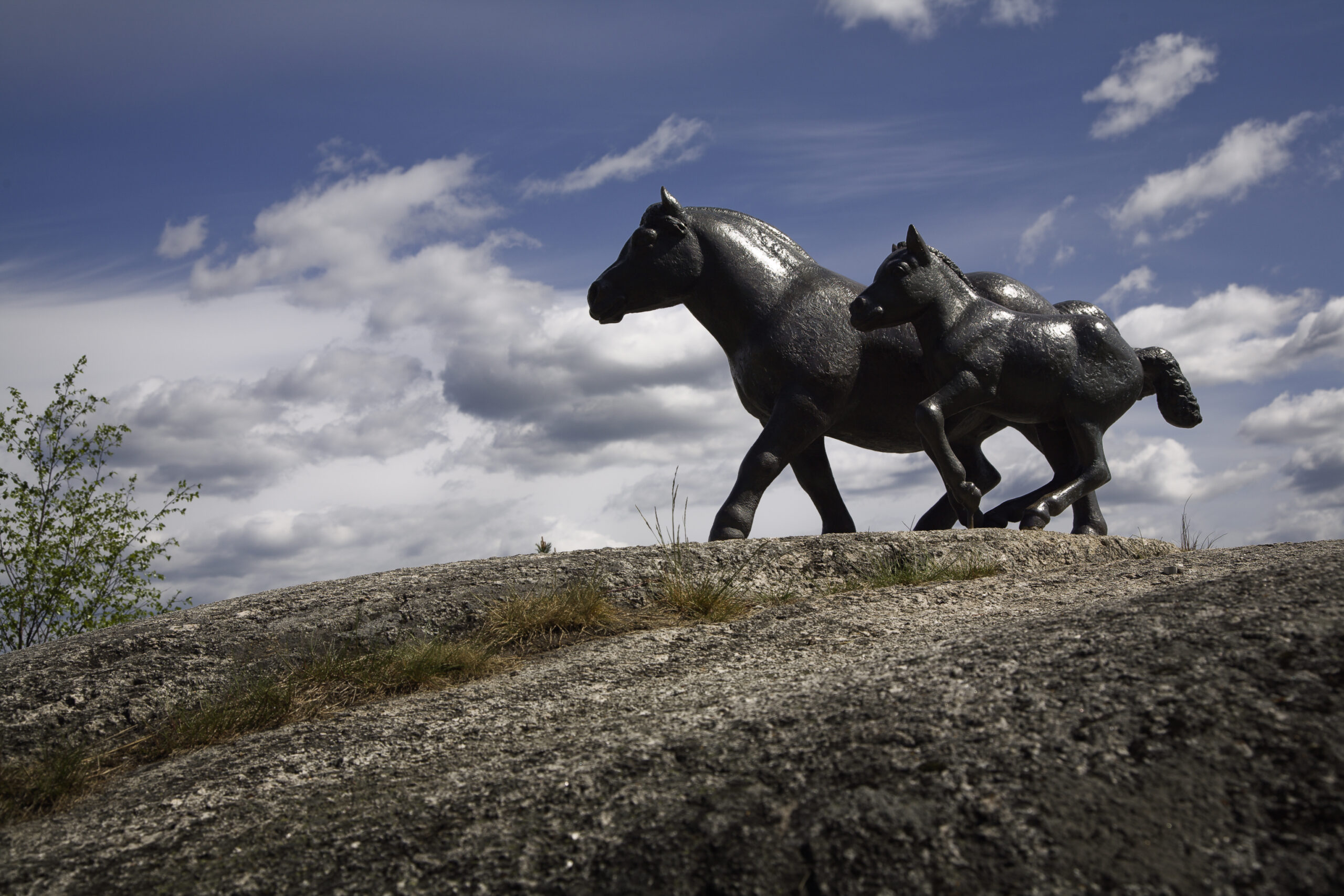 Två skulpturer av hästar på berg.