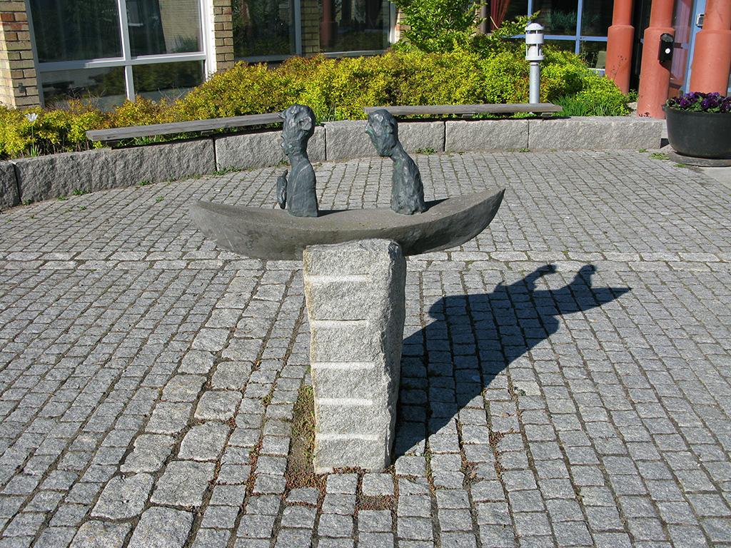 En skulptur med två gubbar som sitter i en båt.