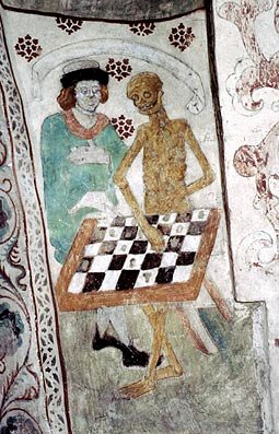 En man står bredvid ett skelett och de står framför ett bord.