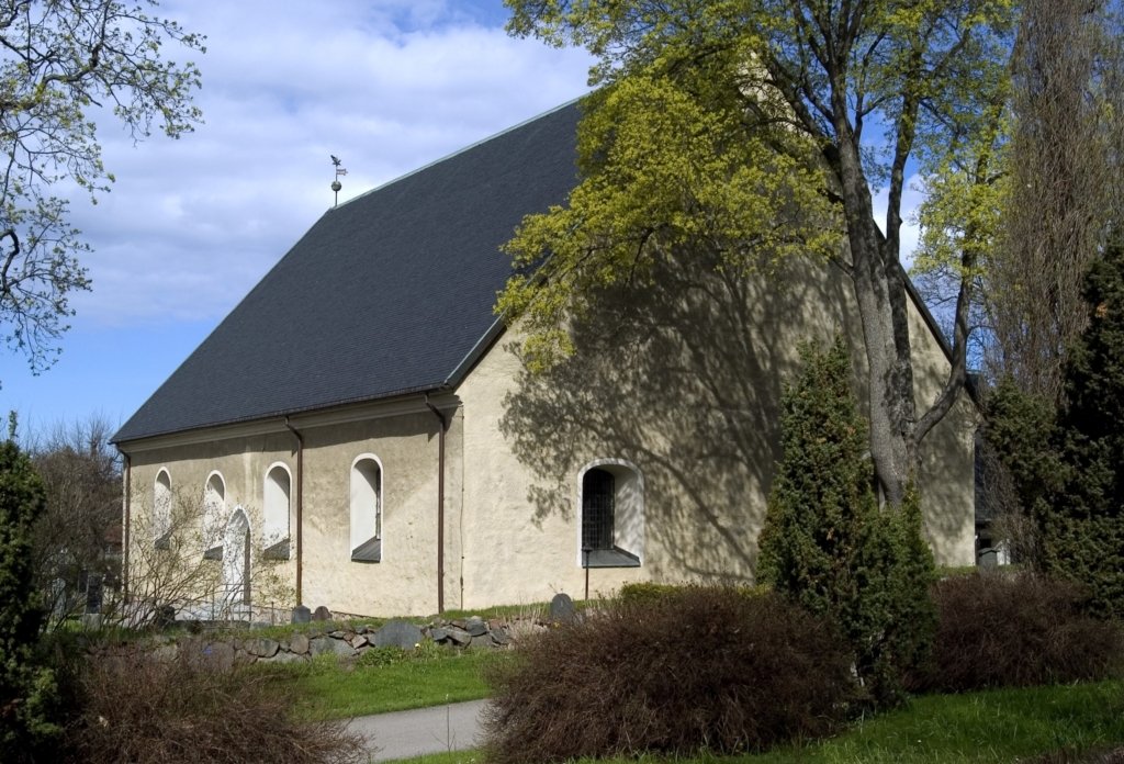 En kyrka i sten med svart tak.