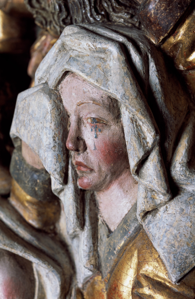 Detaljbild från altarskåp av Marias ansikte med tårar som rullar nedför kinden