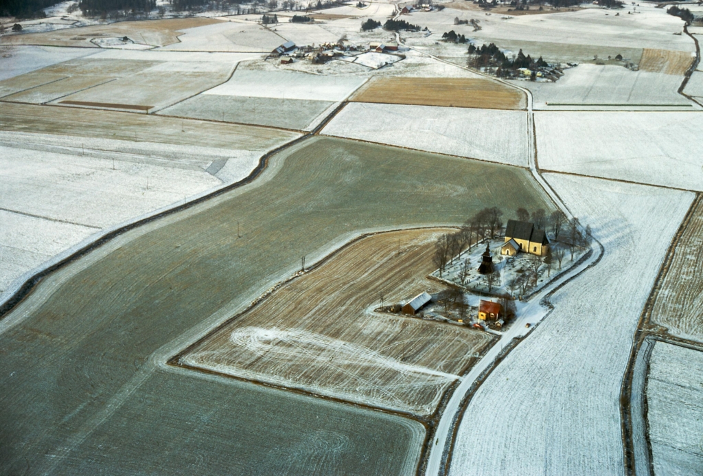 Flygfoto av kyrka mitt i ett snötäckt landskap