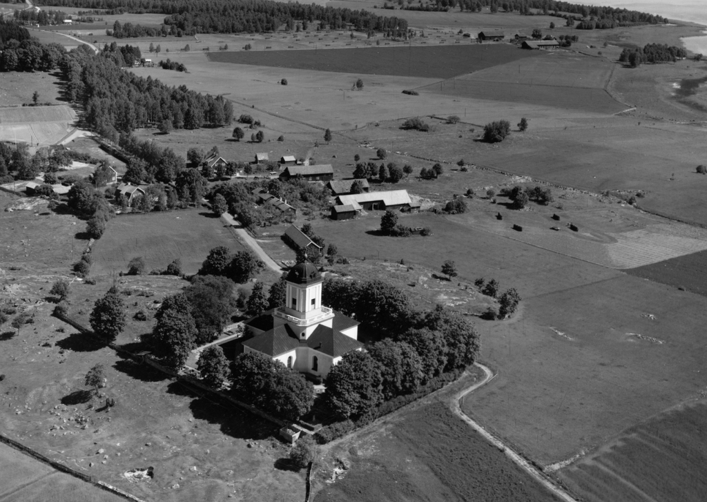 Svartvitt flygfoto över Fasterna kyrka och kringliggande landskap