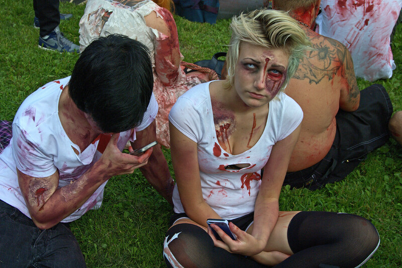 Fyra personer utklädda till zombies, med blodiga sår och trasiga kläder.