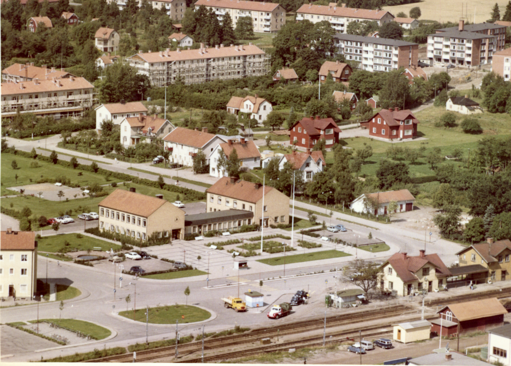 Flytfoto över den ganska låga bybyggelsen och järnvägen.
