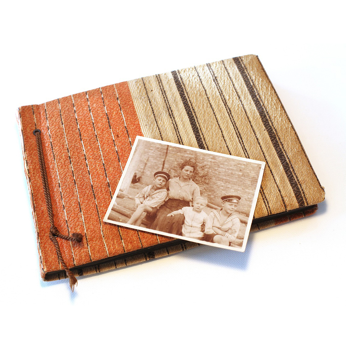 Ett svartvitt fotografi av en familj ligger uppepå ett fotoalbum.