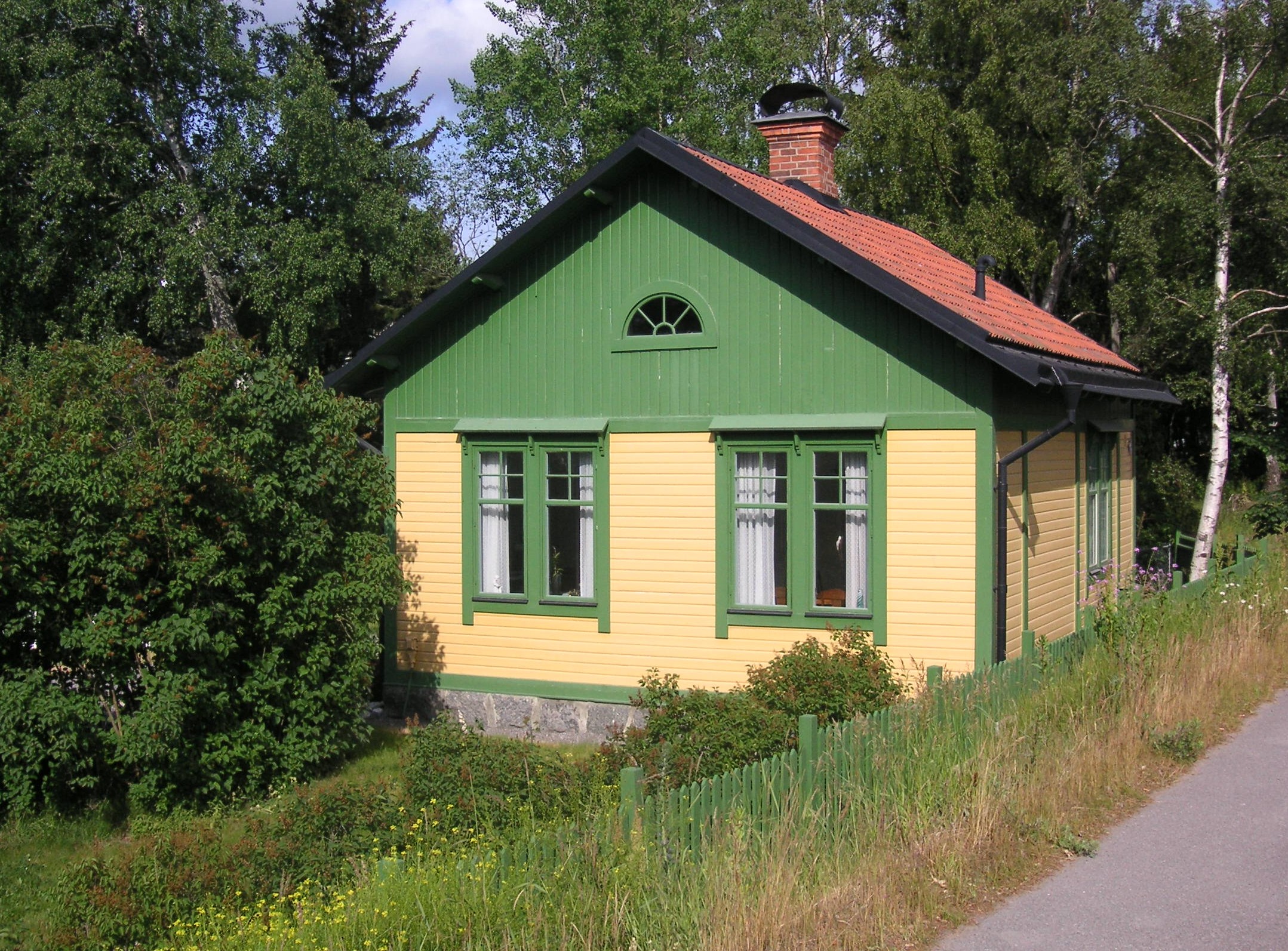 Stugan är målad i gult och grönt.