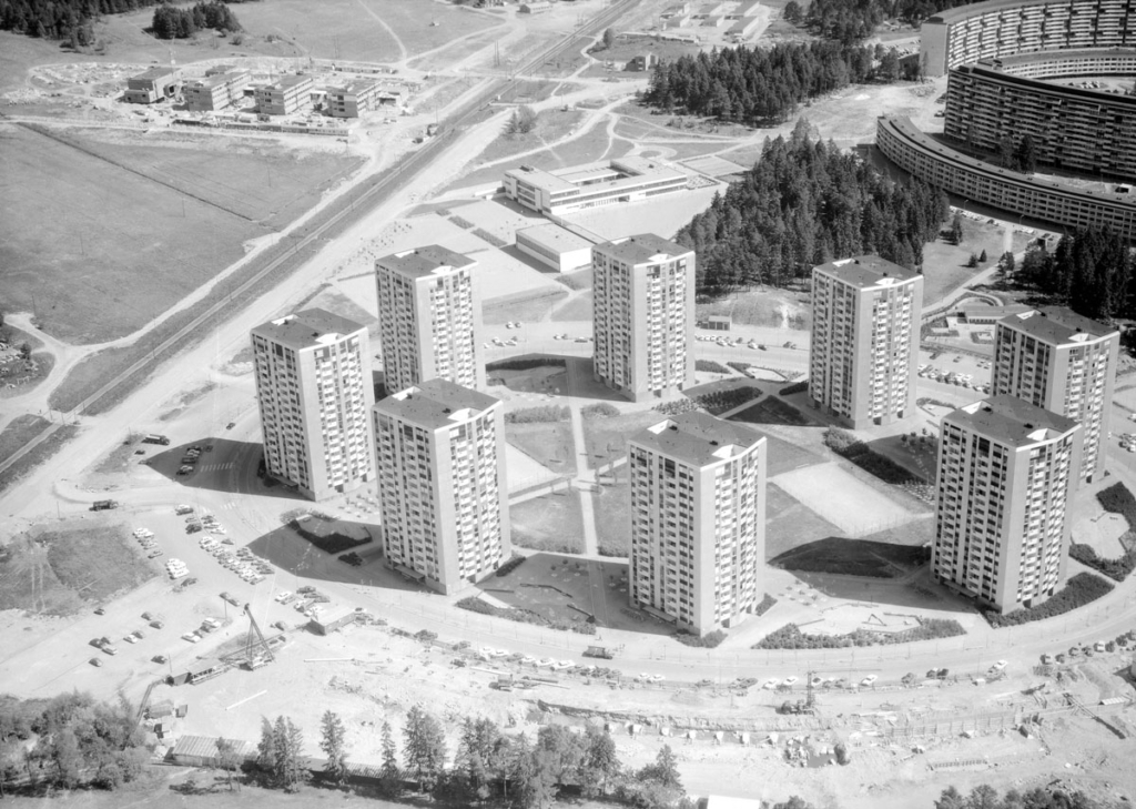 Svartvitt flygfoto. Höghus i cirkel.