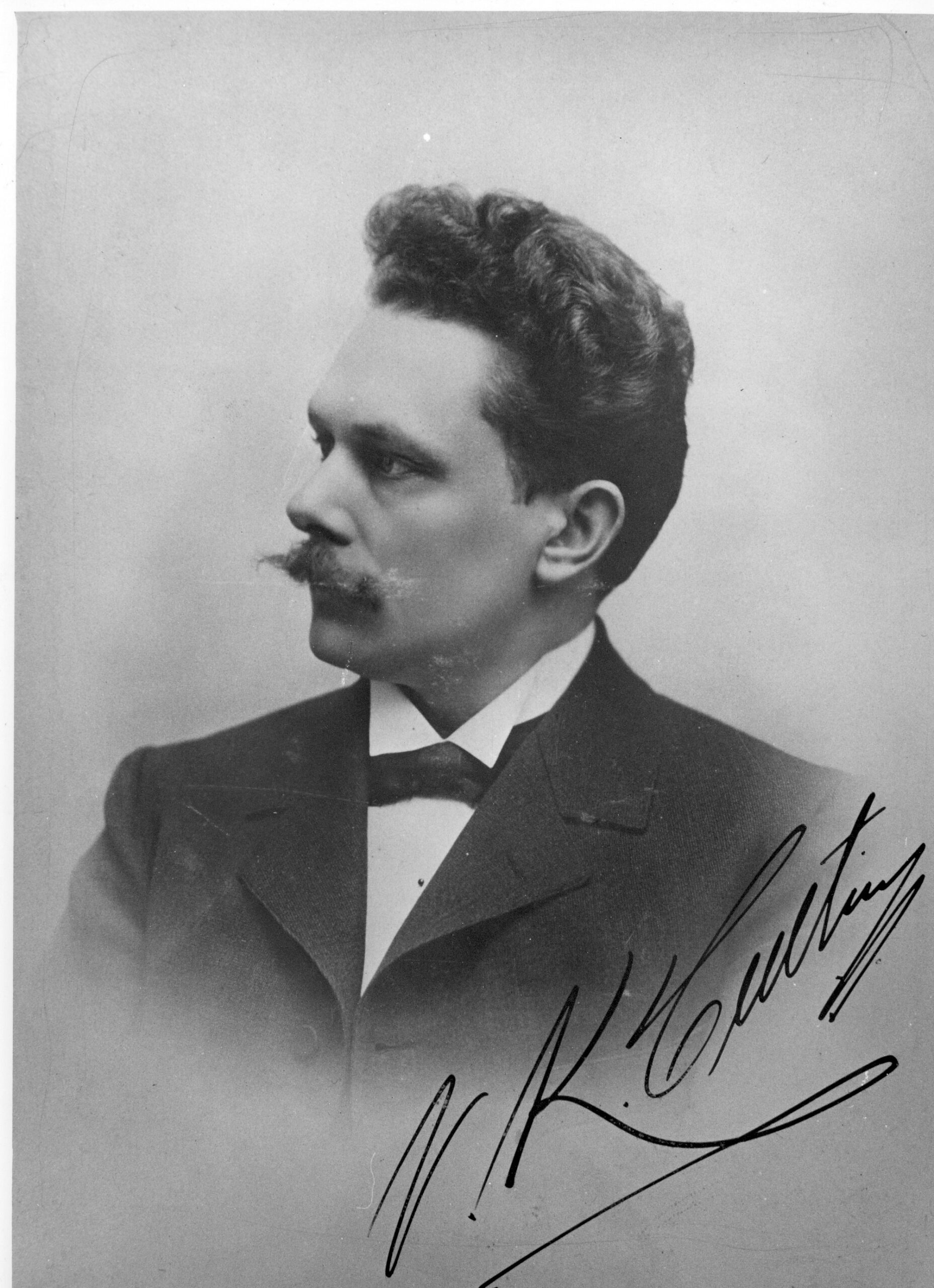 Porträttfoto i profil. man med mustasch och fluga. Signerat.