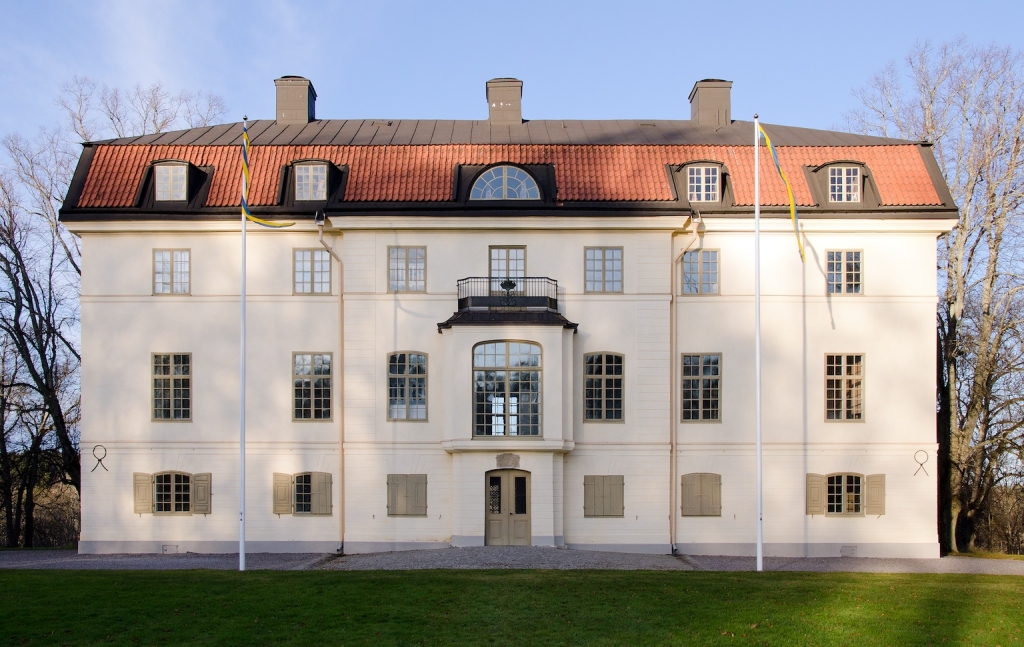 Slottet rakt framifrån. Tre våningar och en takvåning. Stort fönster i mitten.