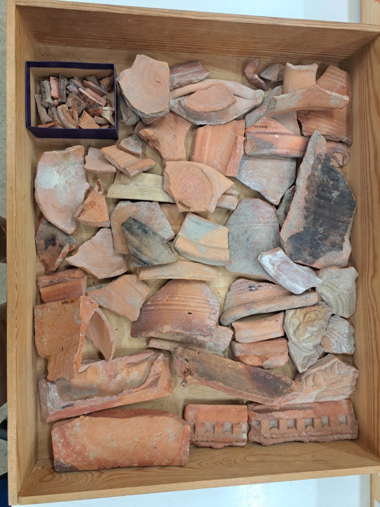 Delar av keramik i en trälåda.