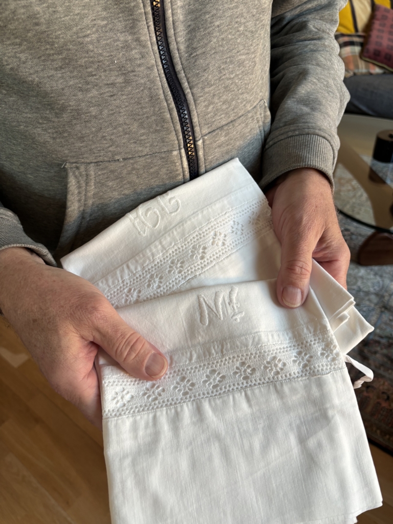 En man håller två broderade örngott i sina händer.