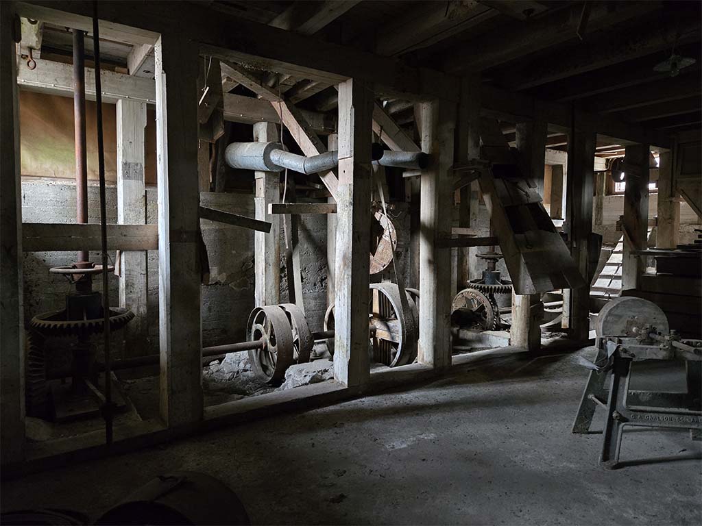 Foto med träkonstruktioner och cementgolv inomhus.
