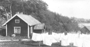 Tvätt på tork utanför torpet vid sjön.