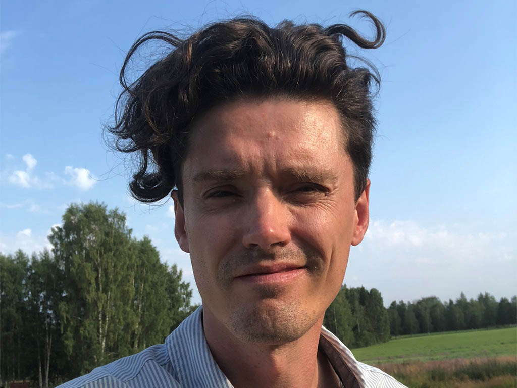 Foto av en man med mörkt hår utomhus.