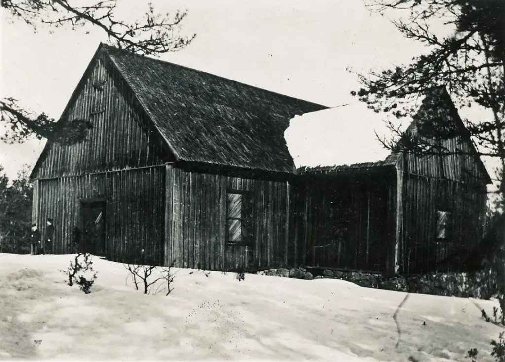 Svartvitt foto av en träkyrka utan utsmyckning.