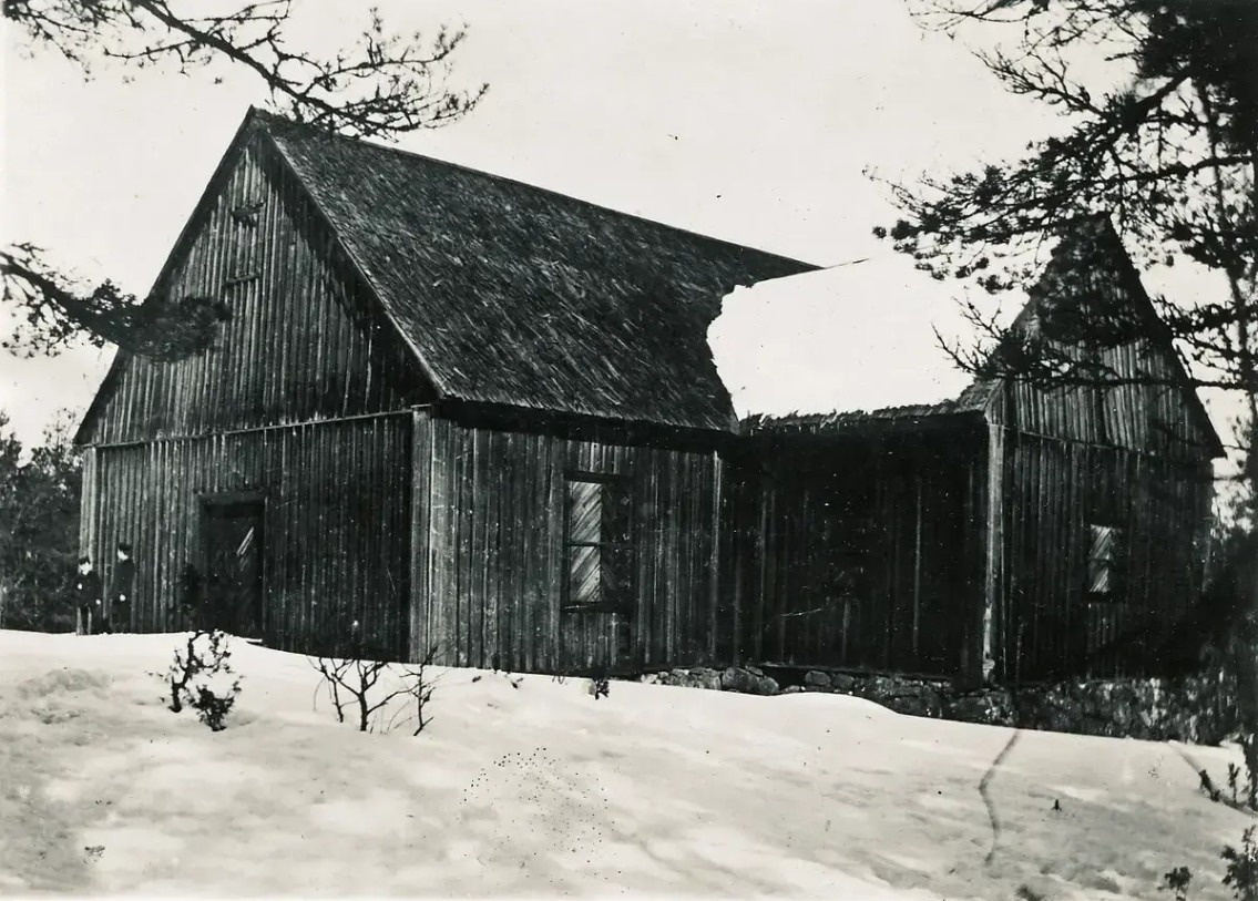 Svartvitt foto av en träkyrka utan utsmyckning.