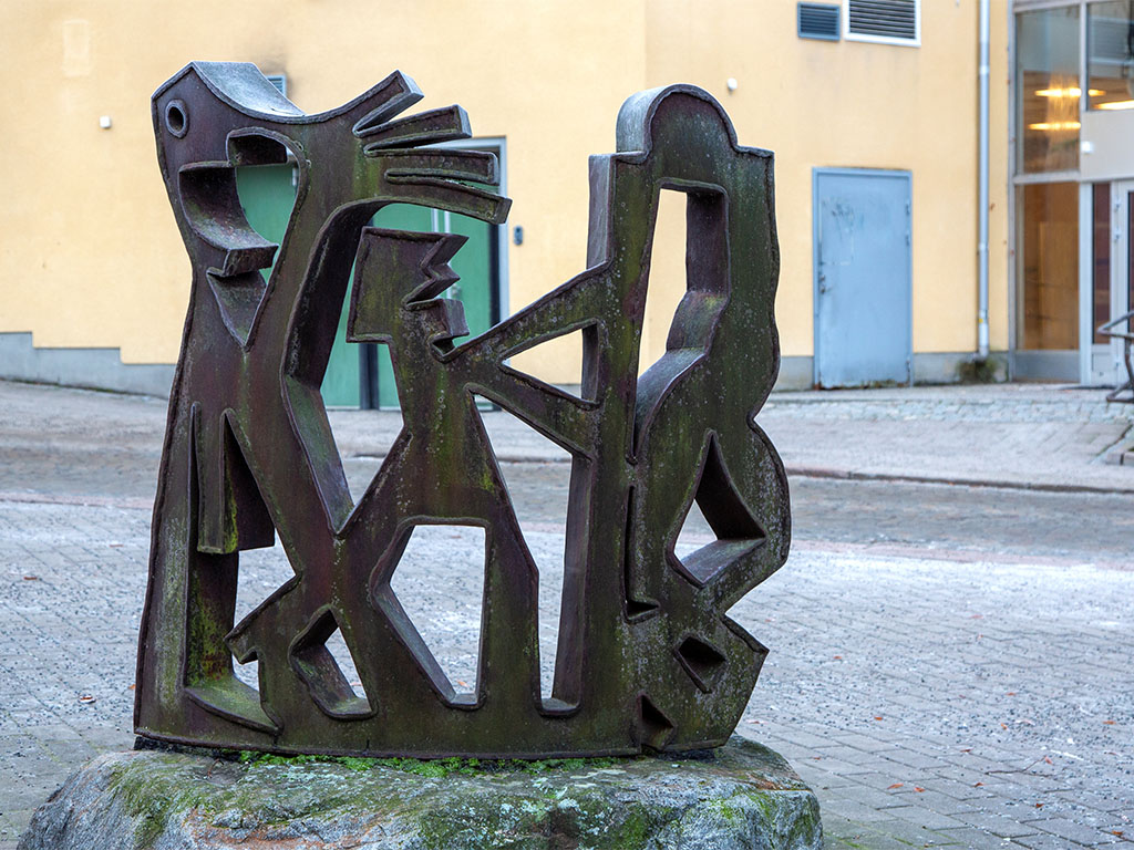 Skulptur i metall med tre figurer.
