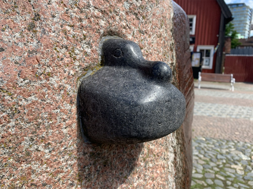 And av svart sten på en rödaktig skrovlig sten.