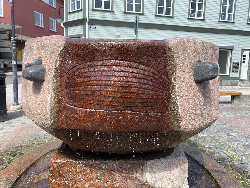 Rund fontän på en sockel med rinnande vatten.