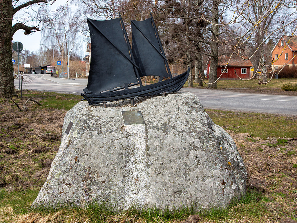 Svart segelbåt av järn på en grå sten.