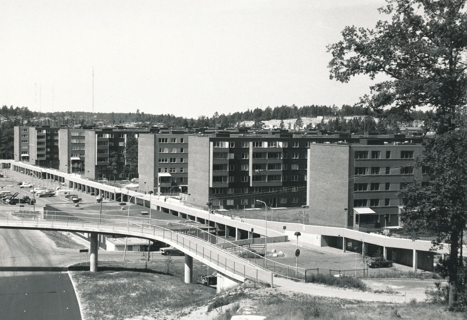 Sex stora höghus står på rad längst en parkeringsplats.