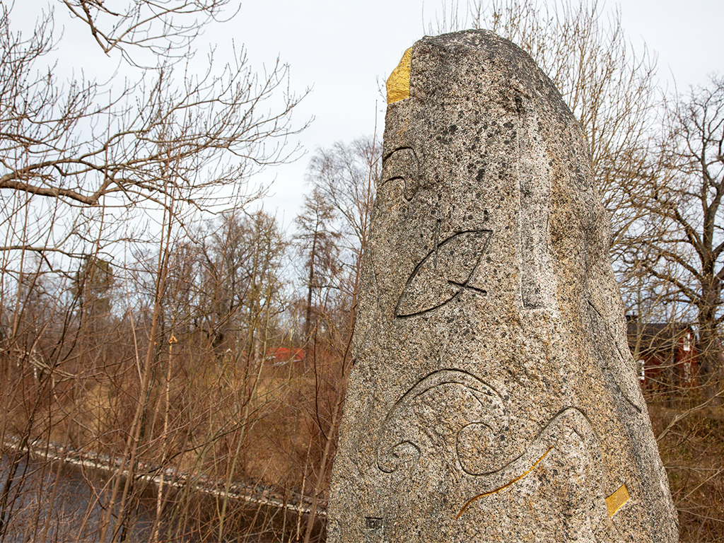 Toppen av sten med ristningar och inslag av guld på vissa ställen.